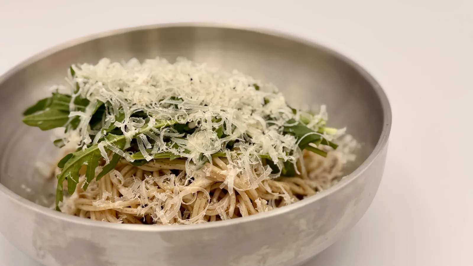削りチーズをたっぷり絡めたソバックスの創作冷麺「チーズ冷麺」を器に盛った様子