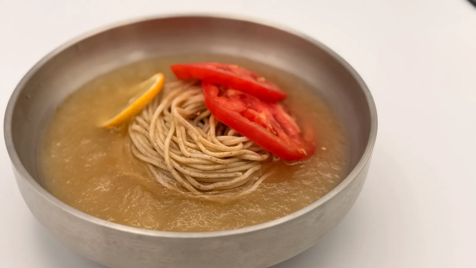 凍らせた牛骨スープとトマトを合わせたソバックスの冷麺「氷結トマト冷麺」を器に盛った様子
